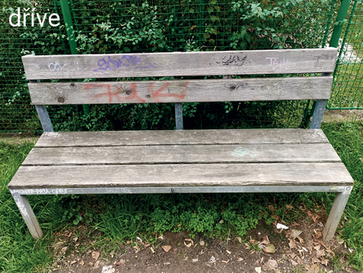 Zchátralá řepská lavička s odřeným nátěrem a graffiti před opravou